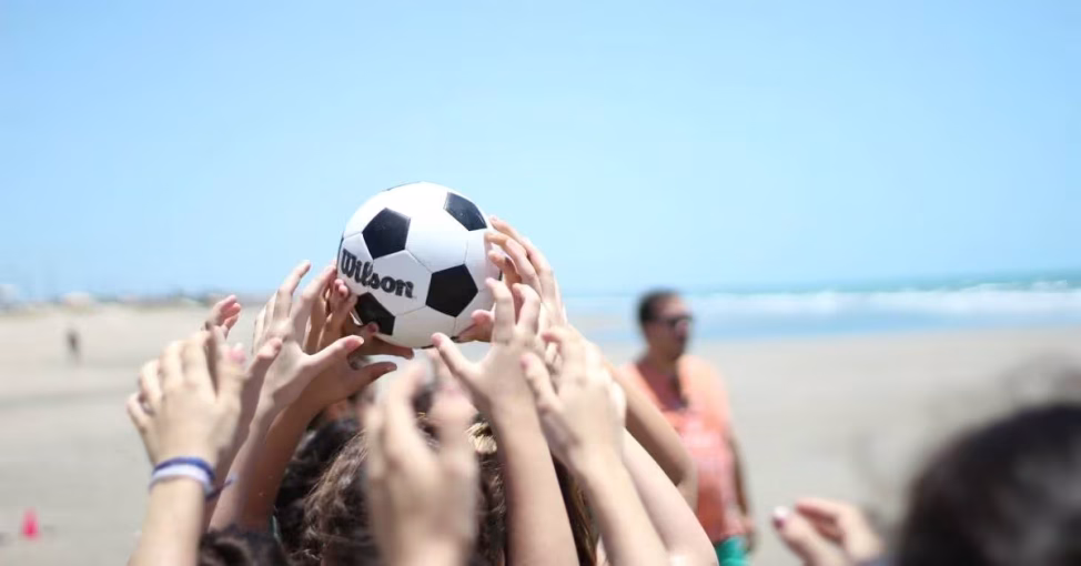 Colegi amuzându-se la Beach Ball Race, un joc de coordonare team building outdoor.