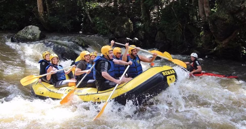 Echipaj vâslind pe râu la Rafting, o activitate team building pe apa organizată de Yes Academy.