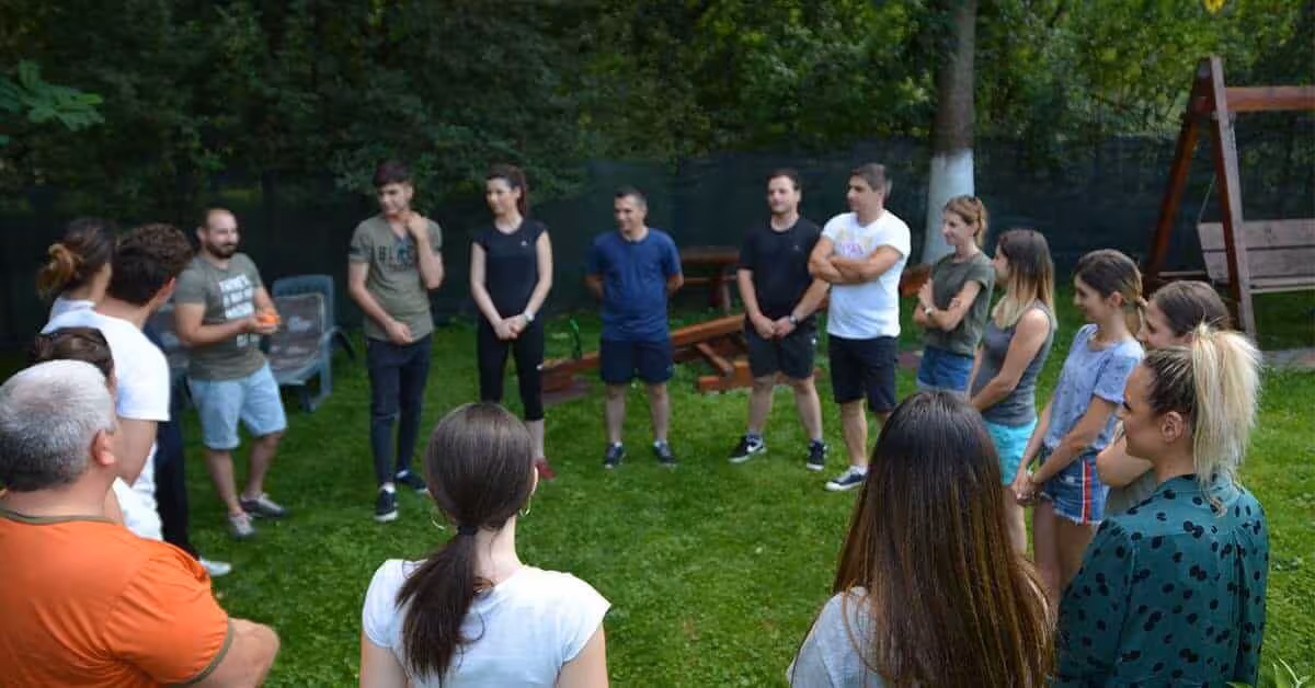 Echipă colaborând în natură la Origins, o activitate de supravietuire team building.