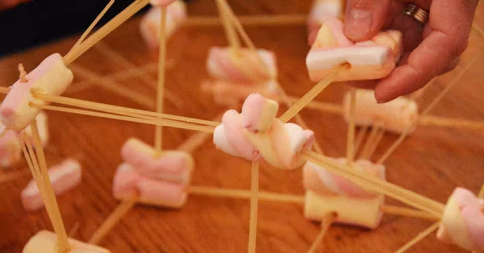 Echipă construind un turn din spaghete la Spaghetti Tower, un exercitiu de inovatie team building.