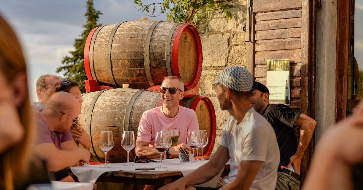 Colegi relaxându-se și ciocnind pahare la Wine, un atelier de degustare team building.